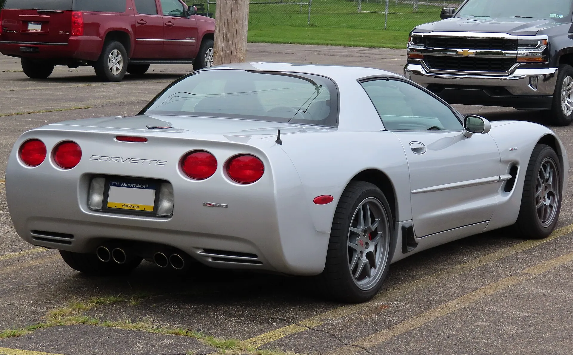 Silver 2001 Chevrolet Corvette Z06 seen from the rear right, showing four round taillights, quad exhaust tips and the Z06 badge.