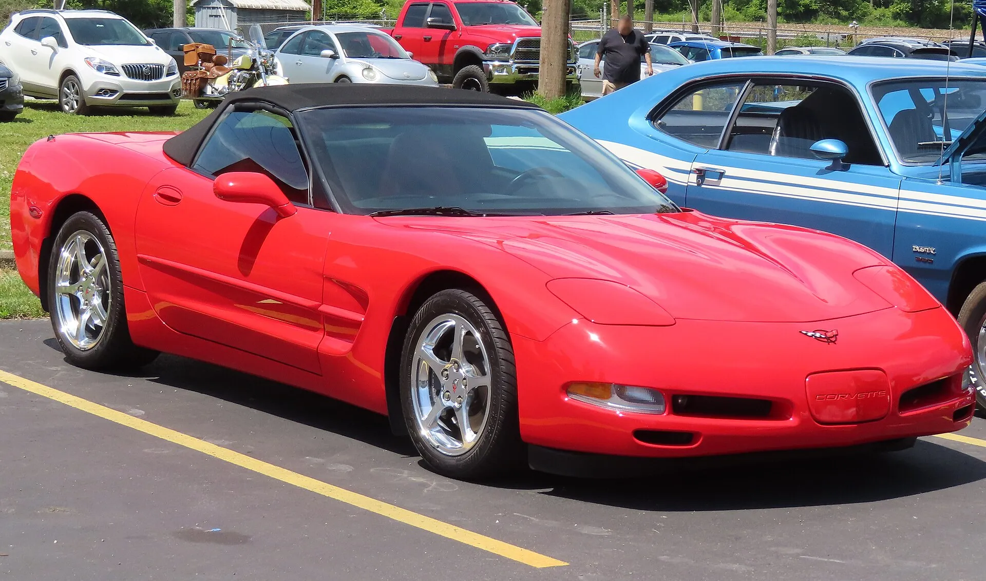 Torch Red 2002 Chevrolet Corvette convertible with its black soft top up, parked at a car show, seen from the front right.