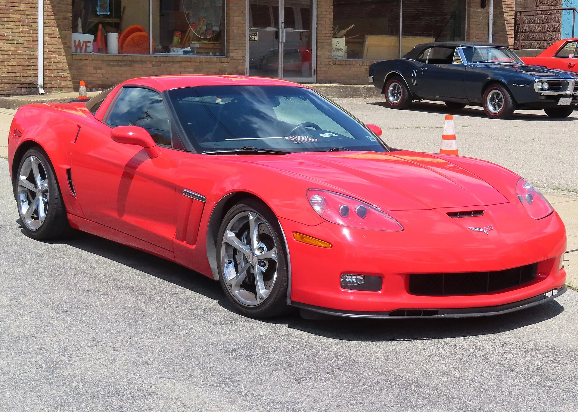 Red 2011 Chevrolet Corvette Grand Sport coupe seen from the front right, showing its wide fenders and fender badge